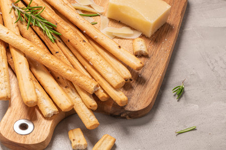 Traditional italian breadsticks grissini with rosemary, parmesan cheese, olive oil, garlic and salt...
