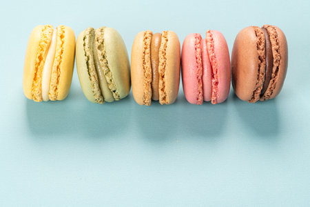 Cake macaron or macaroon on turquoise background from above, colorful almond cookies, pastel colors, vintage cardの写真素材