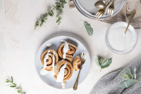Cinnamon rolls or cinnabon  with icing for Christmas. Homemade traditional winter festive dessert buns. Pastry food for breakfast on white backgroundの写真素材