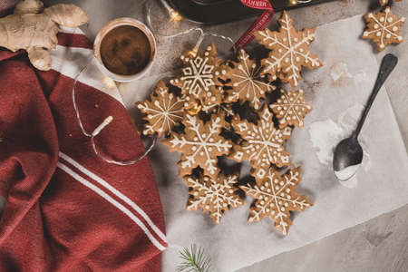 Gingerbread cookies with icing on countertop with festive lights. Christmas cookies snow flakes decorated with sugar frosting. Christmas holiday tradition and adventの写真素材