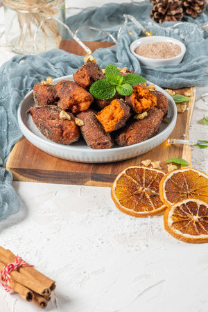Traditional portuguese Christmas sweets named Bilharacos with sugar and cinnamon on kitchen countertop. This sweets are made with pumpkin. Is traditional in Aveiro regionの写真素材