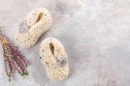 Knitting baby booties and wool yarns on soft background. Hand-made socks for the babyの写真素材
