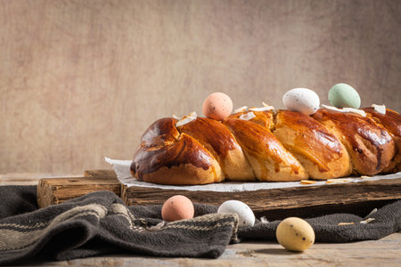 Portuguese traditional Easter cake. Folar with eggs on easter table. Blossom tulips, colorful...