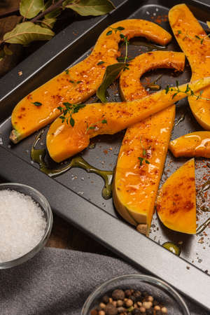 Many bright slices of pumpkin prepared for baking in the oven.の写真素材