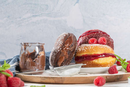 Bolas de Berlim, or "Berlin Balls". Portuguese fried dough with sugar, Filled with chocolate or raspberry jam. Portuguese fried dough with sugar. Chocolate and  beetroot  Berlin Balls stuffed with varの写真素材