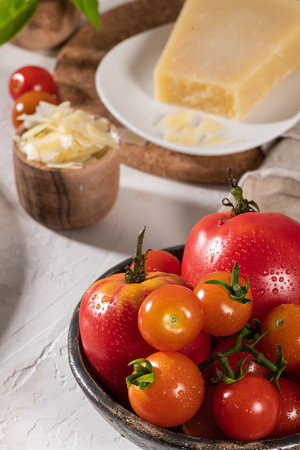 Delicious parmesan cheese, tomato and basil. Fresh ingredients for cooking pasta or sauce. Italian cuisine concept.の写真素材