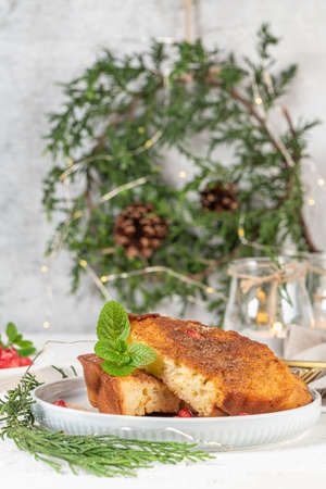 Traditional Christmas Rabanadas with lemon zest, pomegranate, pine nuts and cinnamon. Spanish Torrijas or french toasts close up on the countertopの写真素材