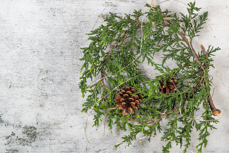 Christmas wreath with green branches, pine cones and natural festive decorations. Rustic christmas wreath hanging on the wall. Seasonal holiday adventの写真素材
