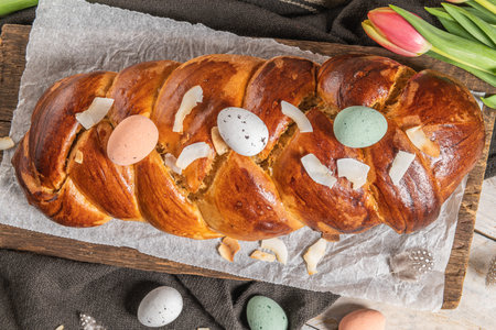 Portuguese traditional Easter cake. Folar with eggs on easter table. Blossom tulips, colorful...