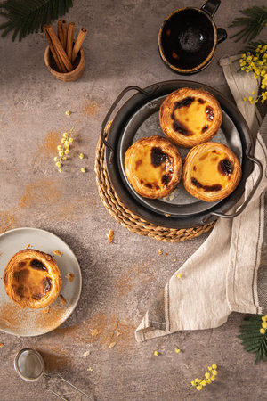 Traditional Portuguese pastry Pastel de Nata or Pastel de BelÃ©m served with cinnamon powder in a...