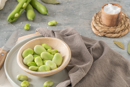 Fresh and raw green broad beans on kitchen tableの写真素材