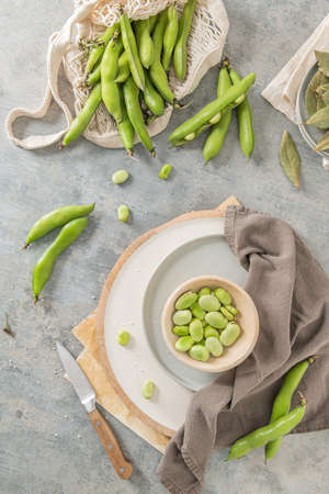 Fresh and raw green broad beans on kitchen tableの写真素材