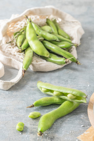 Fresh and raw green broad beans on kitchen table