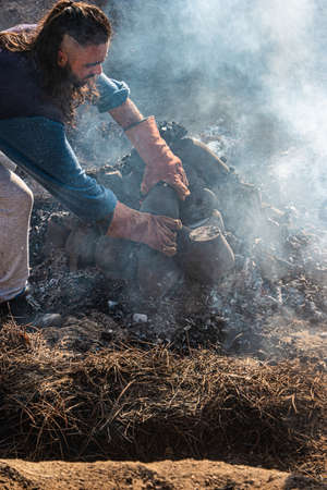 AMARANTE, PORTUGAL - CIRCA APRIL 2022: Final stage of uncovering the bonfire with the pieces of clay piled up during the cooking process of the black clay of Gondar on CIRCA 30, 2022 in Amarante, Portugal.のeditorial素材