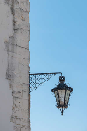 Old and vintage design street lamp bulb with blue sky background. Building illumination. Retro lantern lightingの写真素材