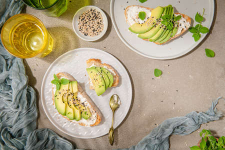 Healthy toast with avocado cream cheese and wheat bread on a plate. Delicious snacks and avocado sandwiches. Food composition, tasty Italian meal.の写真素材