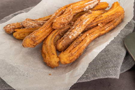 Churros, typical sweet from Brazil and America, fried and stuffed with sweet milk, covered in sugar, tradition in popular festivalsの写真素材