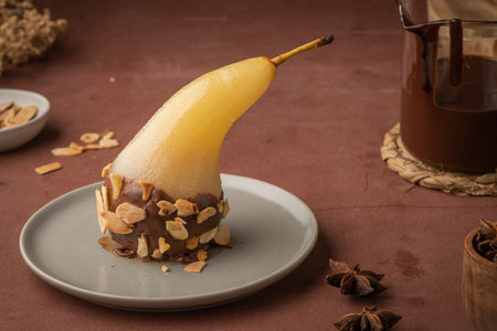 Poached gourmet conference pear with chocolate ganache and sliced almond. Delicious traditional dessert for holiday.の写真素材