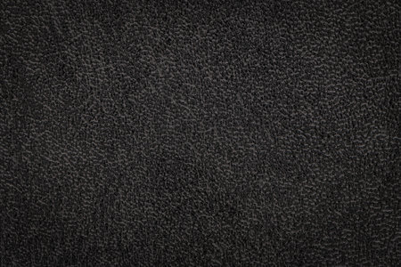 Black artificial or synthetic leather background with neat texture and copy space. Fabric sample with leather-like finish aimed for upholstery, fashion, sewing or footwear projectsの写真素材