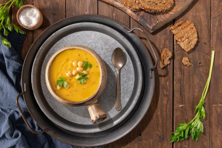 Pumpkin and chickpeas soup on brown rustic wooden background. Top viewの写真素材