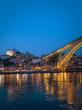 The iconic Dom LuÃ­s I Bridge, illuminated against the night sky, stands as a symbol of Porto s industrial heritage and architectural beauty.の写真素材