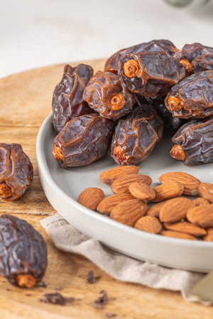 Medjool dates and almonds on a plate, showcasing a healthy snack option with rich textures and natural colors, perfect for nutritious eating and culinary inspirationの写真素材