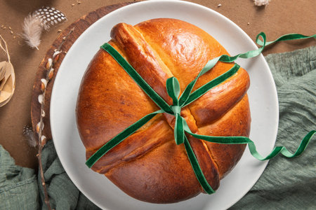 Portuguese traditional Easter cake Folar without eggs on easter table with green ribbon and festive...