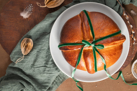 Portuguese traditional Easter cake Folar without eggs on easter table with a green ribbon and...