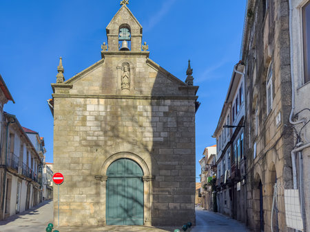 The Misericordia Church in Vila Real, Portugal, stands on a narrow cobblestone street with residential buildings on either sideの写真素材