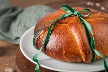 Portuguese traditional Easter cake Folar without eggs on easter table with a green velvet ribbon