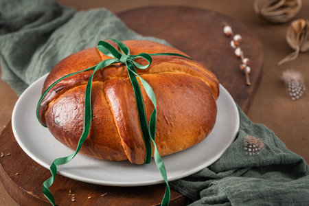 Portuguese traditional Easter cake Folar without eggs on easter table with a green ribbon