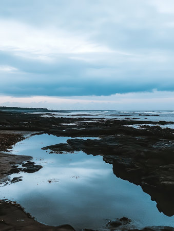 Serene Coastal Rocks Reflecting Sky Peaceful Ocean Tide Pool Tranquil Seascape Dramatic Cloudscapeの素材