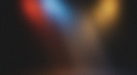 A grainy, multicolored gradient background featuring red, blue, and yellow hues, creating an abstract texture ideal for various design applications, including web design, print media, and digital art, evoking a sense of depth and visual interest.の素材