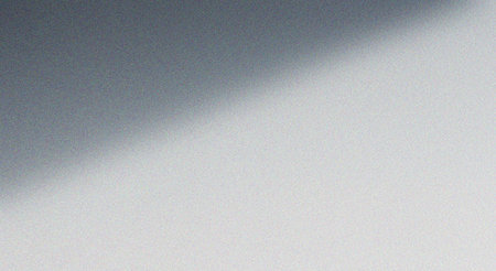 This image features a serene gray gradient background with a soft shadow, creating a smooth transition from dark to light. The subtle gradient effect adds depth and visual interest, making it ideal for use in graphic design, web design, and other creative projects where a minimalist aesthetic is desired.の素材