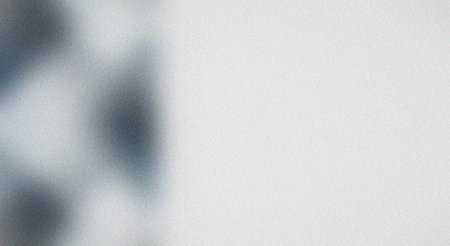 This image features a grainy gradient background with soft shadows and blurred texture, creating a subtle abstract design element suitable for various graphic design projects, presentations, or digital art.の素材