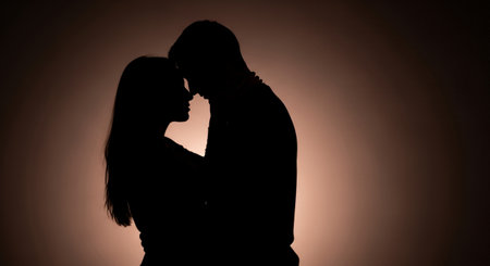 Silhouette of a loving couple in love on a brown backgroundの素材