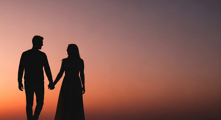 Silhouette of a man and woman holding hands on sunset backgroundの素材