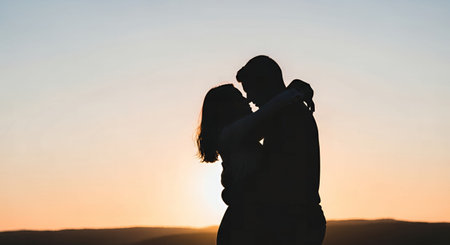 Silhouette of a loving young couple on the background of the sunsetの素材