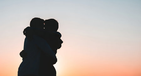 Silhouette of a loving couple on a background of the setting sunの素材
