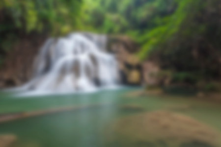 Blurred waterfall background in tropical forest in thailand