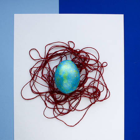 Festive egg. Happy Easter. The decor of the thread. Blue shades. Composition on top.の写真素材