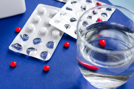 Glass of water and pills. Taking pills on schedule. Course of treatment. The concept of healthy...
