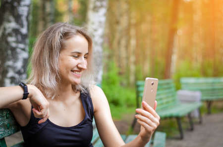 The girl communicates via the Internet. Talk face to face. Modern communication through distances. Blonde woman in sports clothes. Emotions. Photo.の写真素材