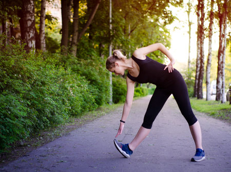 Girl doing a workout in the Park. Healthy lifestyle. Sports activities in the fresh air. Stretching....
