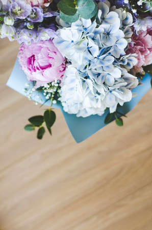 Bouquet of flowers close-up. The view from the top. Standing on the floor, tree. Summer flowers. Peonies, hydrangea and others. Soft focus.の写真素材