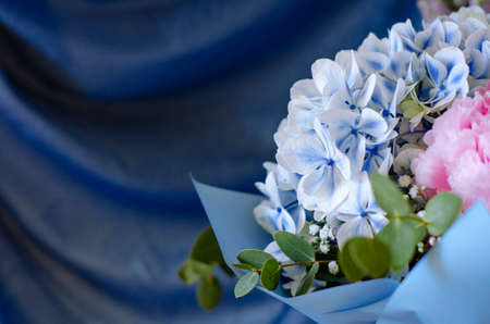 Bouquet of flowers close-up. On a blue background. Still-life. Summer flowers. Peonies, hydrangea and others. Soft focus.の写真素材