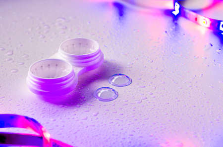 Contact lenses. Case close-up. Lenses are near. Poor vision, eye problems. Health and disease prevention concept. Neon light.の写真素材