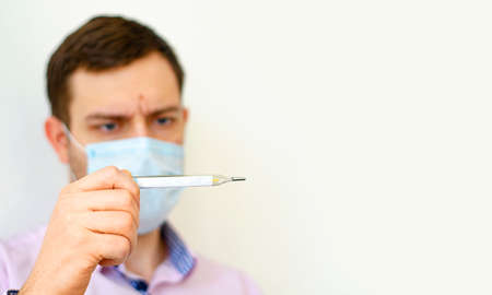Coronavirus. Quarantine. A man in a shirt measures the temperature. High temperature. Virus protection. Coronavirus pandemic in the world.の写真素材