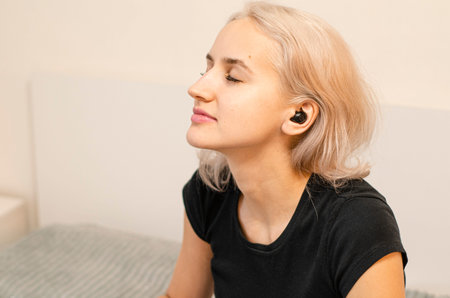 Girl enjoys music in wireless headphones. Modern technologies.の写真素材