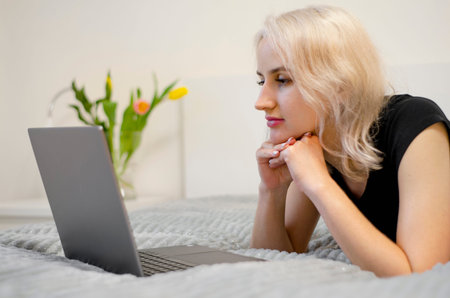 The girl is watching a TV series on a laptop.